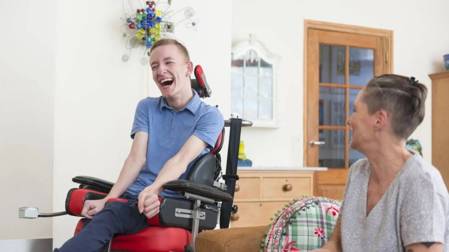 Smiling young adults with disabilities during a wheelchair training session at Saha Supports